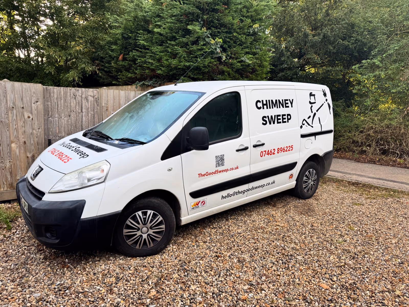 White chimney sweep service van parked on gravel with text and contact details on the side.