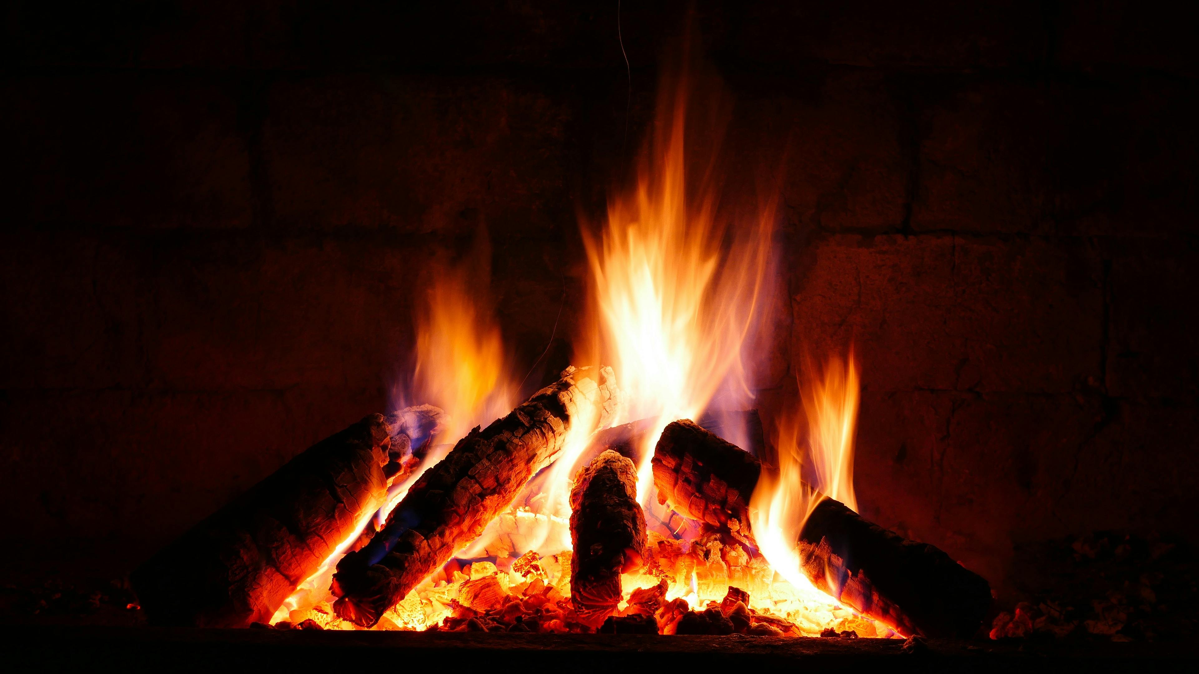 Logs burning against the brick back of an open fire