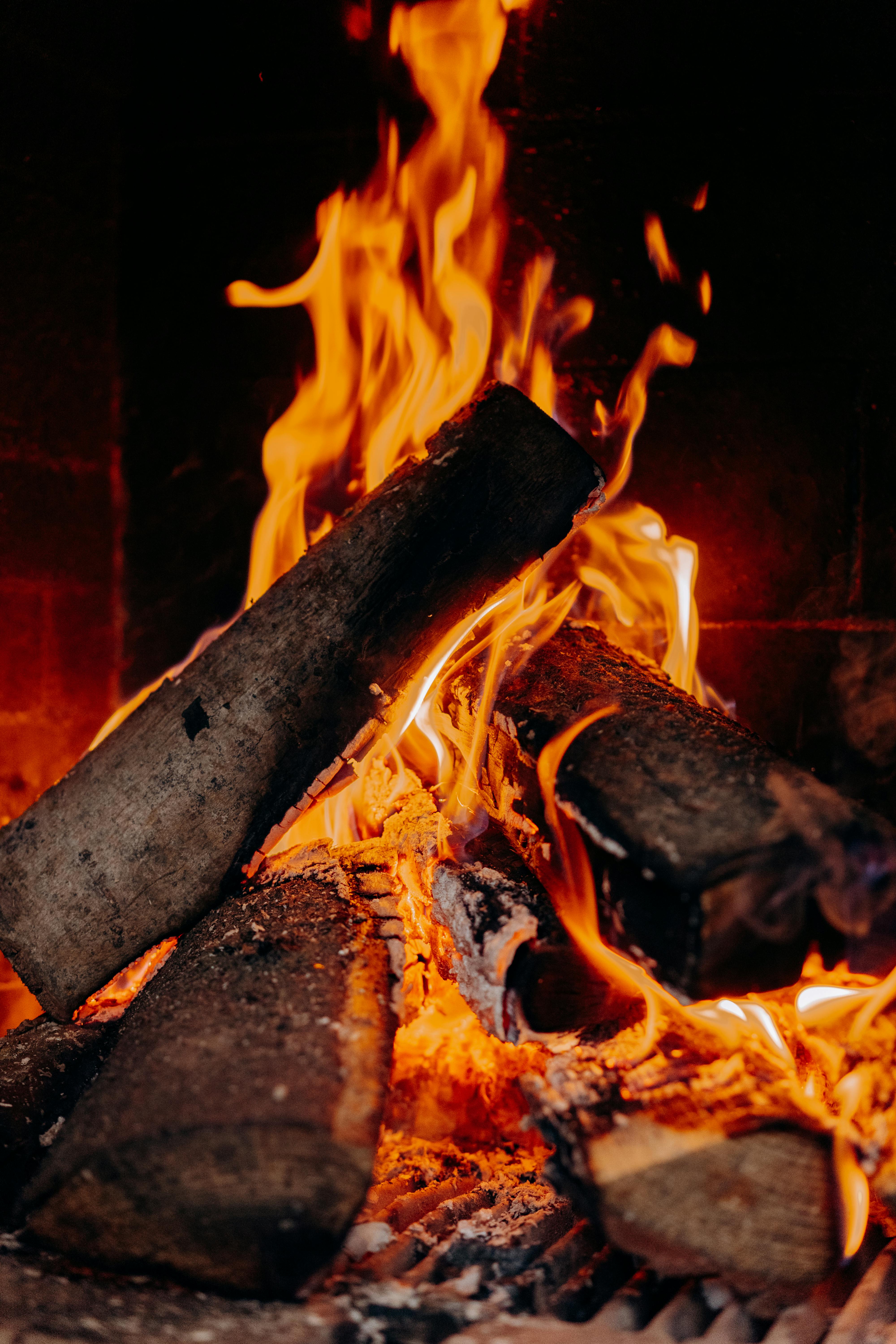 Split logs burning in a brick fireplace