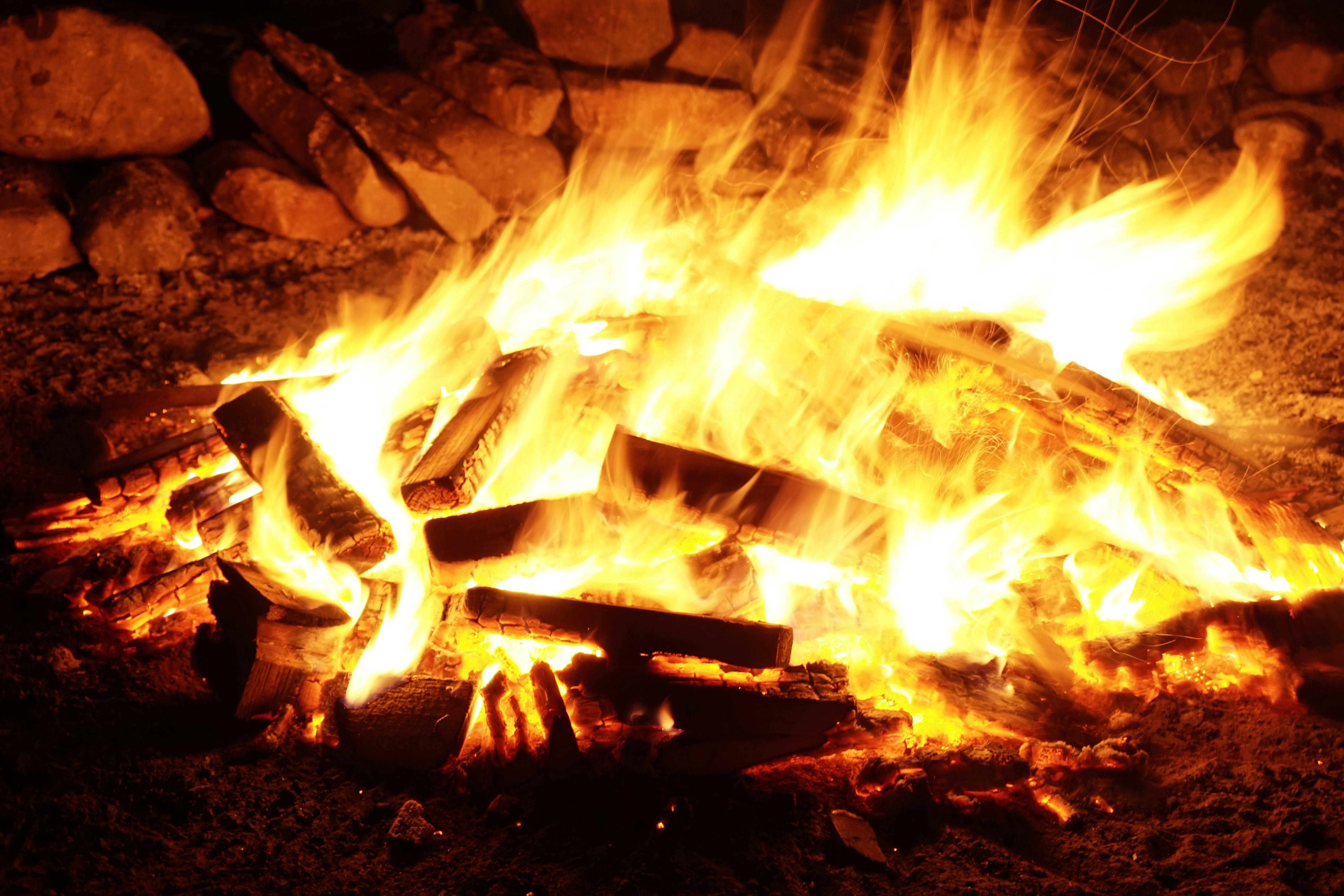 Logs burning brightly in a stone fireplace